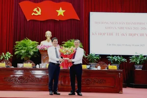 Tân Bí thư Thành ủy Cần Thơ Lê Quang Tùng (trái) tặng hoa chúc mừng tân Chủ tịch UBND TP Cần Thơ Trương Cảnh Tuyên.
