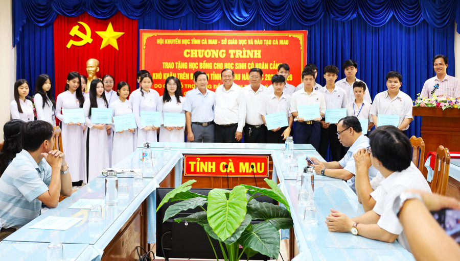 Học sinh được trao tặng học bổng chụp ảnh cùng đại biểu.