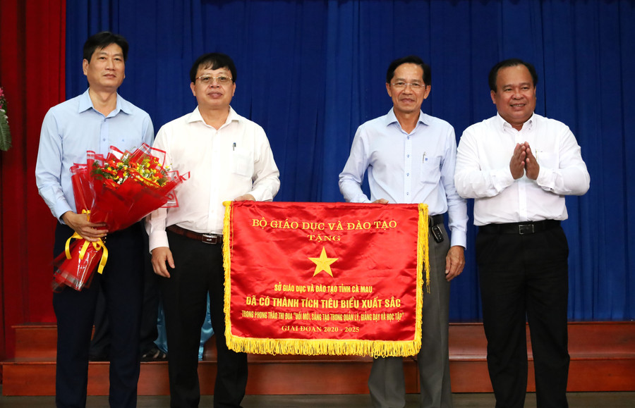Ông Nguyễn Minh Luân (bìa phải) tặng Cờ thi đua của Bộ GD&ĐT cho tập thể Sở GD&ĐT Cà Mau.