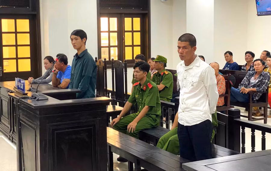 Bị cáo Nguyễn Quốc Tuấn (áo trắng) và Phạm Hoàng Phương (áo xanh) tại phiên tòa. 