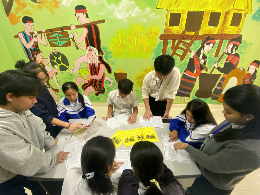 Các bạn học sinh đang học chữ Brũ- Vân Kiều thông qua sổ tay học tập ngoài giờ học.