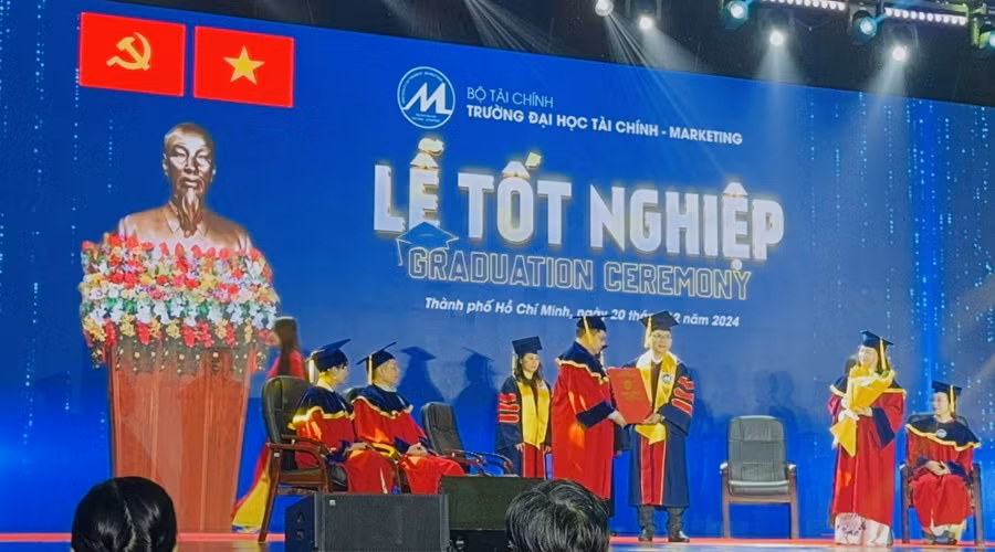 Tân Tiến sĩ Lê Bá Thường (bên phải) nhận bằng trong lễ tốt nghiệp. 