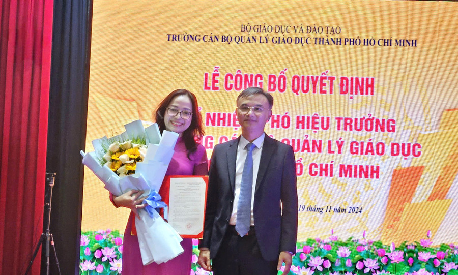 TS Nguyễn Viết Lộc - Vụ trưởng Vụ Tổ chức cán bộ, Bộ GD&ĐT trao Quyết định và tặng hoa chúc mừng cho tân Phó hiệu trưởng.
