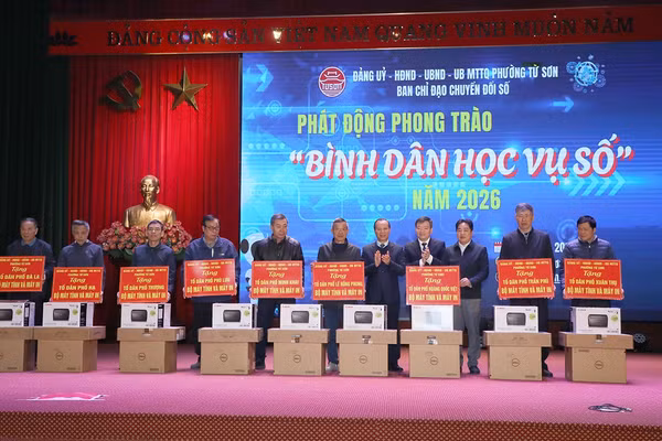 Phó Chủ tịch Thường trực UBND tỉnh Mai Sơn (thứ 5 bên phải) cùng đại biểu trao tặng máy tính và máy in cho các Tổ dân phố trên địa bàn phường.