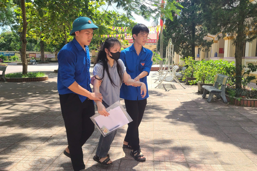 Thanh niên tình nguyện hỗ trợ đưa thí sinh khuyết tật vào phòng thi. 2.jpg