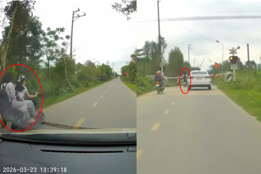 Hai nữ sinh điều khiển xe điện vượt rào chắn khi tàu đến gần. (Ảnh cắt từ clip)