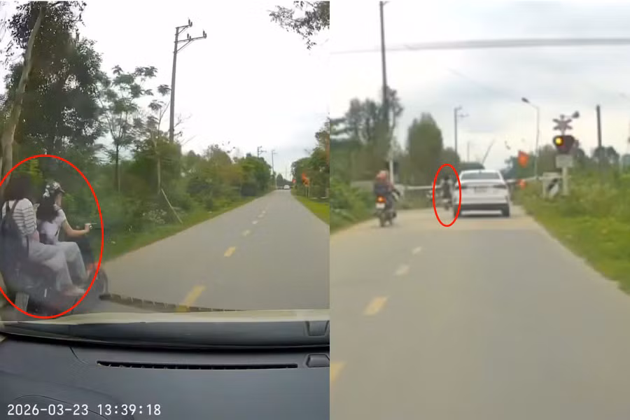 Hai nữ sinh điều khiển xe điện vượt rào chắn khi tàu đến gần. (Ảnh cắt từ clip)