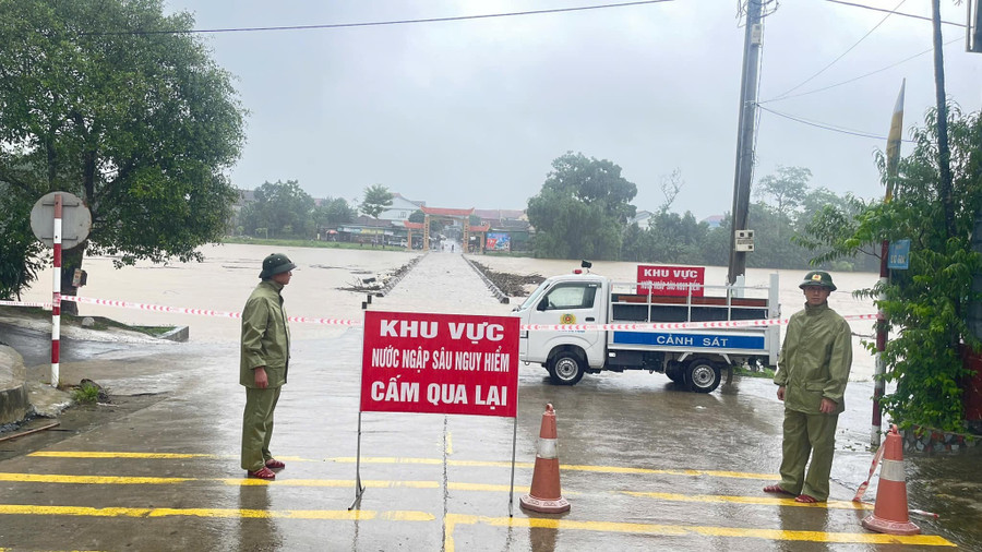 Lực lượng chức năng cắm biển cảnh báo, canh gác không để người và các phương tiện qua lại cầu tràn Phố Giang, thị trấn Phố Châu, huyện Hương Sơn. (Ảnh: A.D)