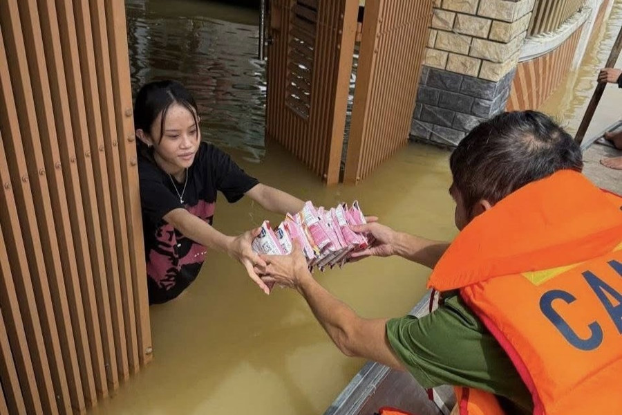 Lực lượng Công an Hà Tĩnh bơi thuyền đến từng hộ dân bị ngập để tiếp tế thực phẩm.