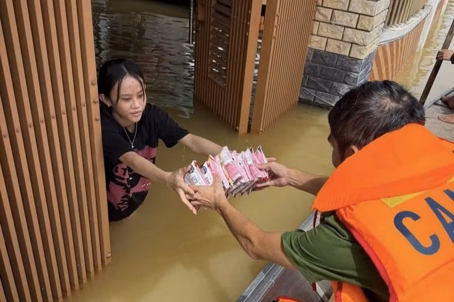 Lực lượng Công an Hà Tĩnh bơi thuyền đến từng hộ dân bị ngập để tiếp tế thực phẩm.