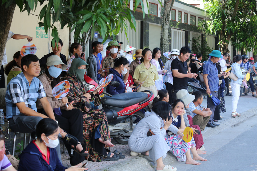 Sau khi các thí sinh bước vào giờ thi chính thức, hàng trăm phụ huynh vẫn ngồi trước cổng điểm thi chờ đợi. 7.jpg