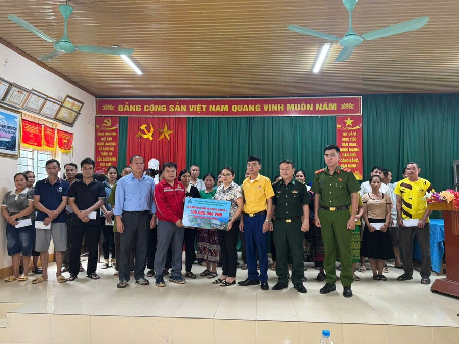 Lãnh đạo Công ty Cổ phần Thủy điện Hủa Na trao 100 triệu đồng đến người dân vùng bão lũ xã Thông Thụ. (Ảnh: V.T)