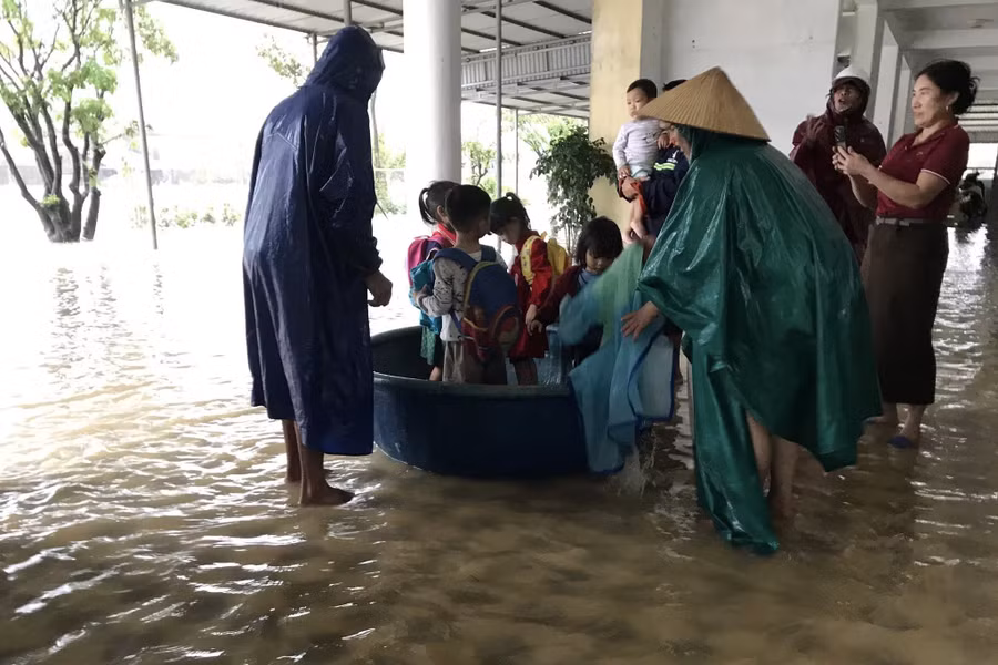 Lực lượng chức năng và giáo viên hỗ trợ đưa học sinh ra khỏi khu vực ngập ở Trường Mầm non Kỳ Thịnh (Phường Vũng Áng, Hà Tĩnh).