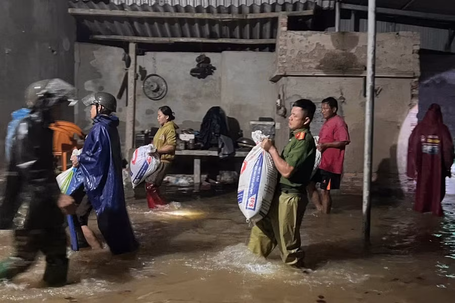 Công an Hà Tĩnh và các lực lượng chức năng hỗ trợ người dân sơ tán của cải do mưa lớn nước dâng trong đêm. (Ảnh: CAHT)