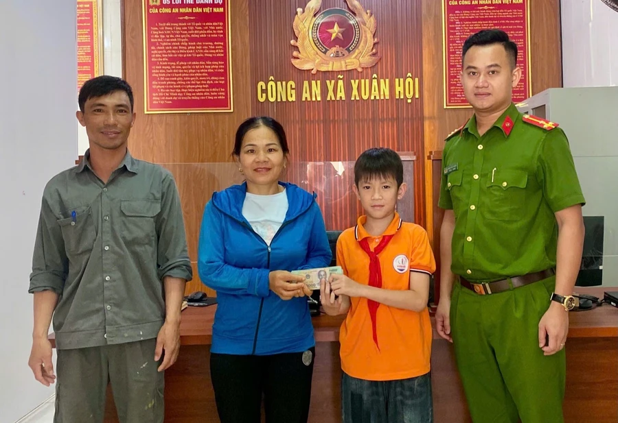 Bố con em Duy đến trụ sở công an trả lại tiền cho người đánh rơi. (Ảnh: Công an cung cấp)