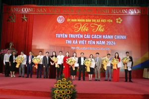 Ông Thân Văn Thuần Phó - Chủ tịch thường trực UBND thị xã, ông Hoàng Văn Tứ - Trưởng phòng Xây dựng CCHC Sở nội vụ tỉnh Bắc Giang trao cờ lưu niệm cho 8 đội dự thi. 