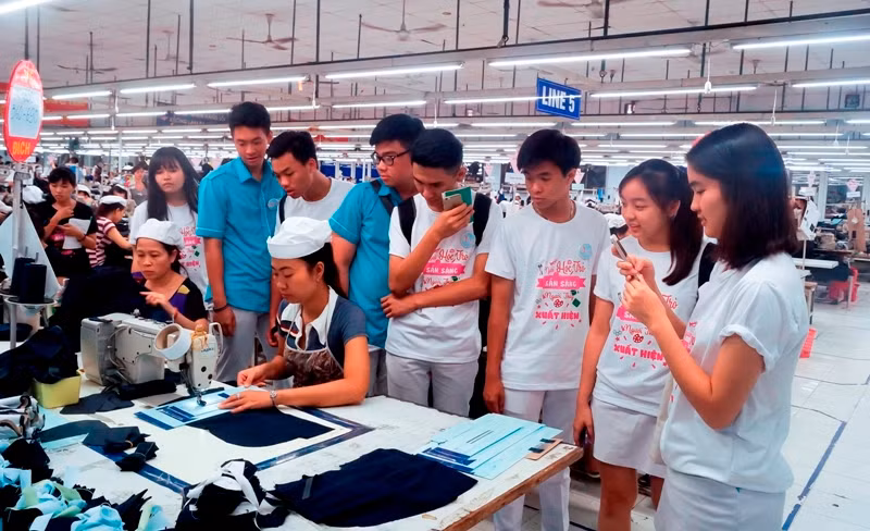 Một nhóm HS tham quan, trải nghiệm ở nhà máy dệt trong chương trình hướng nghiệp của nhóm Vút bay