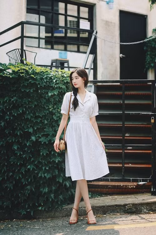 Váy tay bồng, cổ đăng tông dành cho các nàng có vóc dáng nhỏ nhắn. Tông trắng cùng các chi tiết váy xòe sẽ giúp người mặc trông đầy đặn hơn.