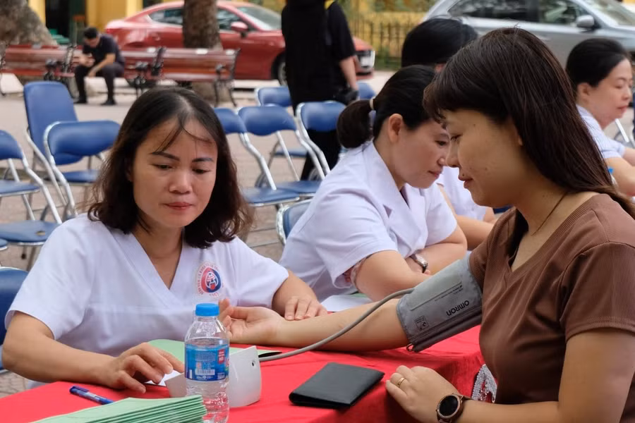 Giáo viên Trường THPT Nguyễn Thị Minh Khai được đo huyết áp khi khám sức khoẻ.