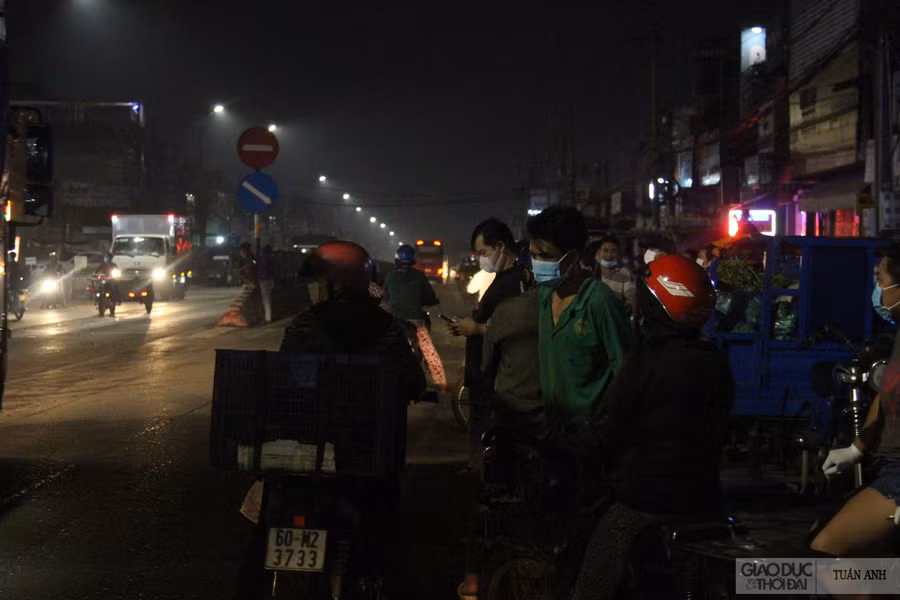 Thời điểm 3 giờ sáng ngày 6/7, vẫn còn đông người đứng trước cổng chợ và 2 bên QL.1A để chờ được vào.