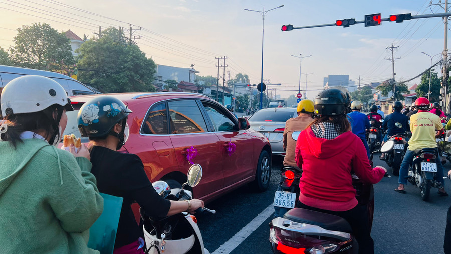 Sĩ tử tranh thủ ăn bánh mì lót dạ trên đường đi thi.