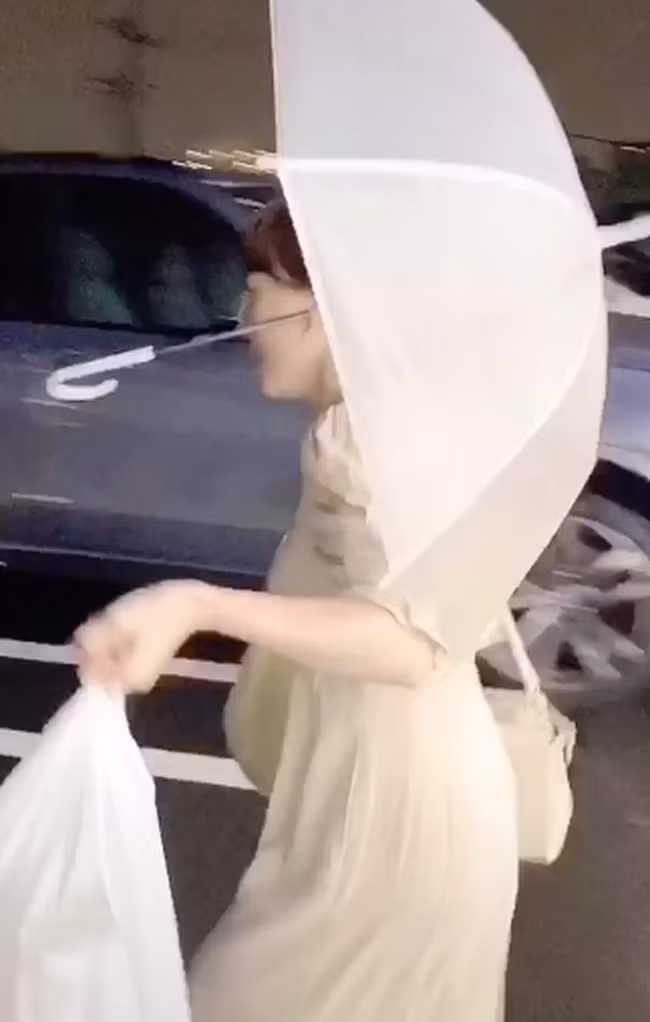 Nhờ chiếc dái tai hữu dụng mà cô gái trẻ có thể thoải mái đi lại mà không cần đưa tay giữ ô nữa.