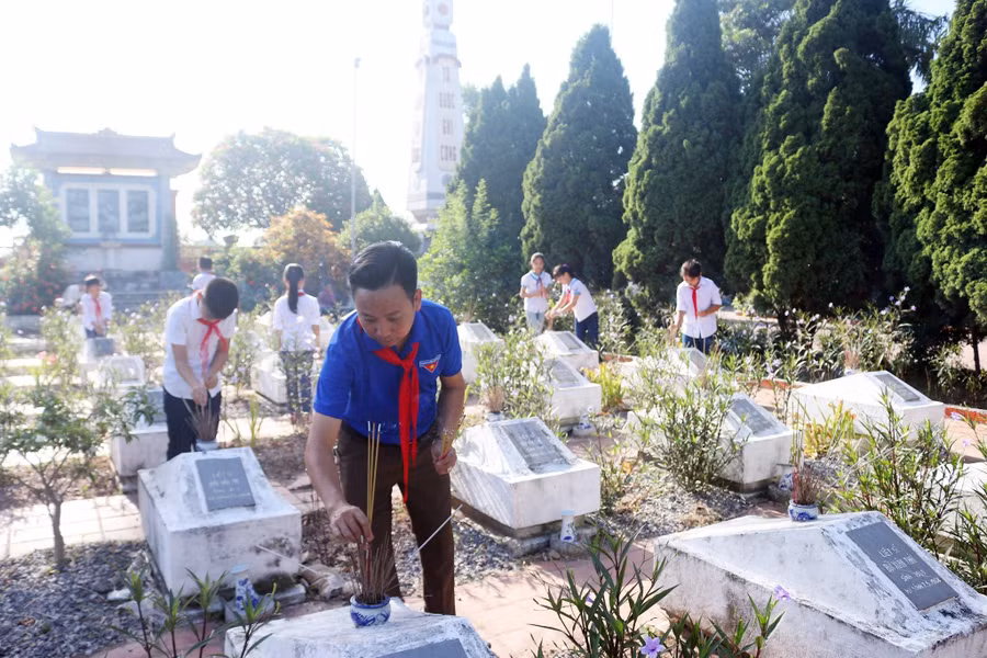 Thầy Mười cùng học sinh Trường Tiểu học Đại Hưng dâng hương tưởng niệm anh hùng liệt sĩ. Ảnh: NVCC.