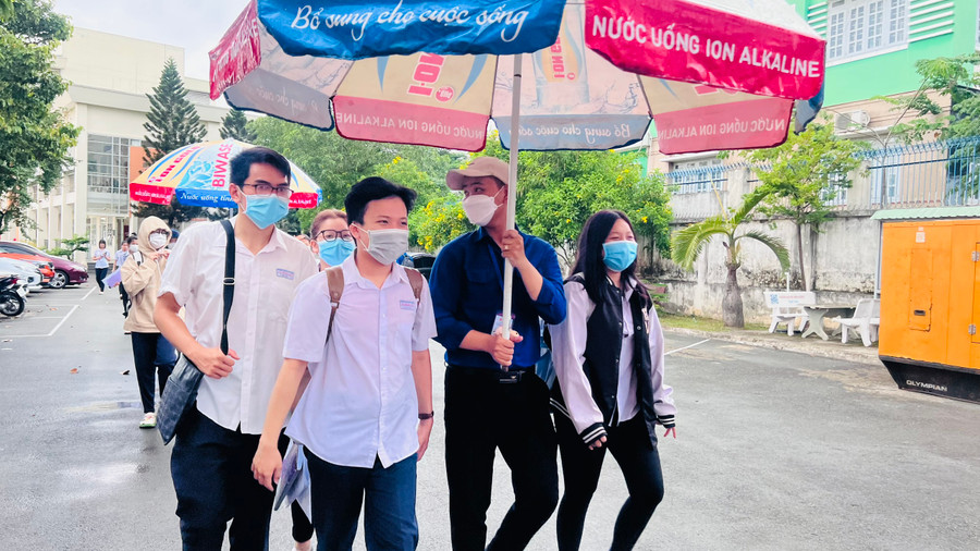 Các thí sinh được tình nguyện viên hỗ trợ ra về khi trời mưa lớn.