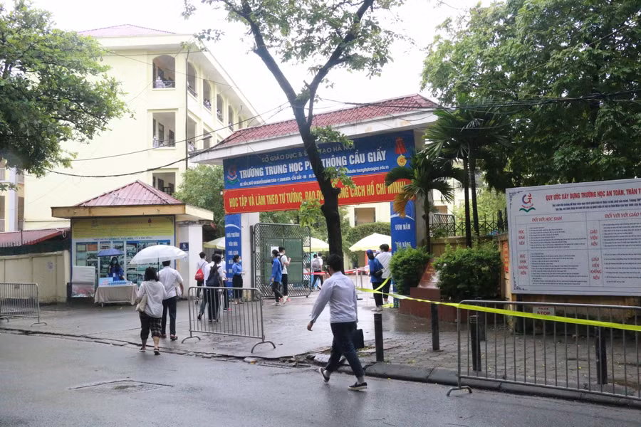 Trước cổng trường, nhóm thanh niên tình nguyện sẵn sàng hỗ trợ thí sinh.