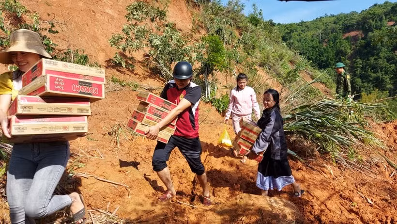 Thầy Hoàng Đức Hòa (đội mũ bảo hiểm đen) nhận lương thực tiếp tế trong đợt lũ. Ảnh: NVCC.