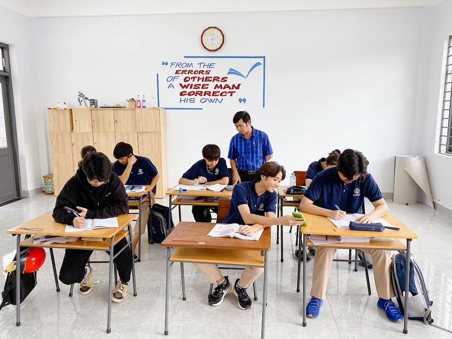 Thầy Hồ Văn Quang hướng dẫn học sinh ôn thi tốt nghiệp THPT. Ảnh: NVCC.
