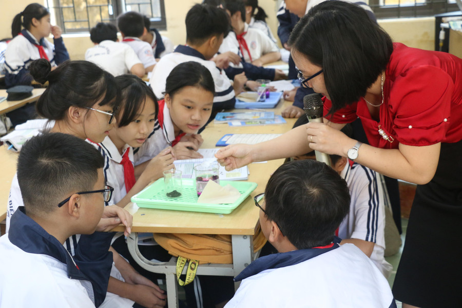 Cô Thùy Dương, Trường THCS Đoàn Thị Điểm, hướng dẫn học sinh làm thí nghiệm. Ảnh: TG.
