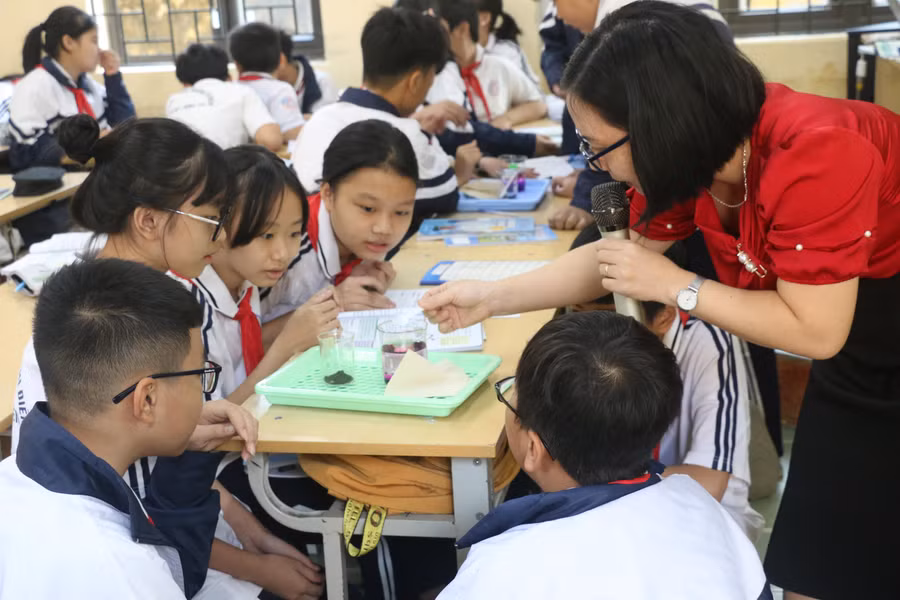 Cô Thùy Dương, Trường THCS Đoàn Thị Điểm, hướng dẫn học sinh làm thí nghiệm. Ảnh: TG.