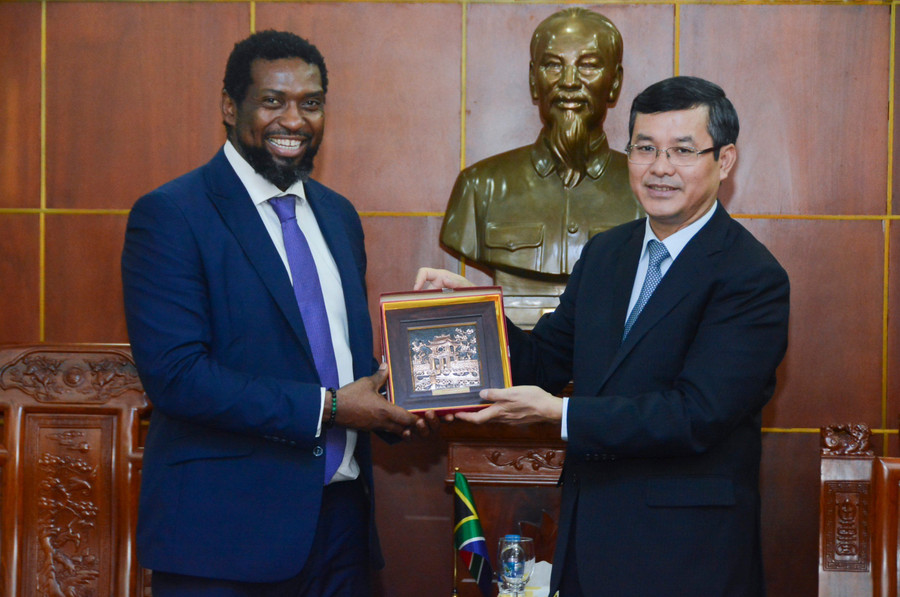 Thứ trưởng Bộ GD&amp;ĐT Nguyễn Văn Phúc (phải) và Thứ trưởng Bộ Giáo dục đại học, Khoa học và Đổi mới Nam Phi Buti Kgwaridi Manamela trao quà lưu niệm.