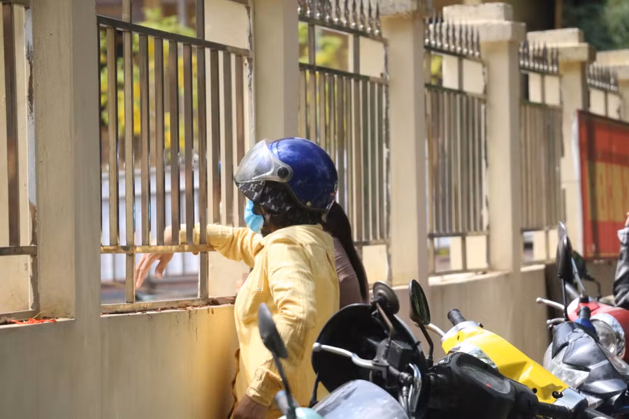 Phụ huynh dõi theo con từ ngoài điểm thi. Ảnh: Phạm Khánh.