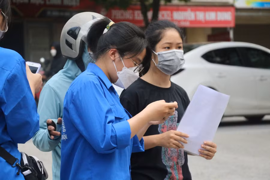 Tình nguyện viên có mặt từ rất sớm để hỗ trợ học sinh, phụ huynh. Ảnh: Phạm Khánh.