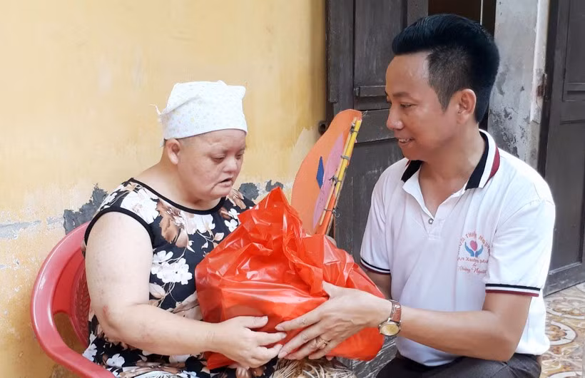 Thầy An Xuân Mười, Trường Tiểu học Đại Hưng, trao quà cho người có hoàn cảnh khó khăn. Ảnh: NVCC.