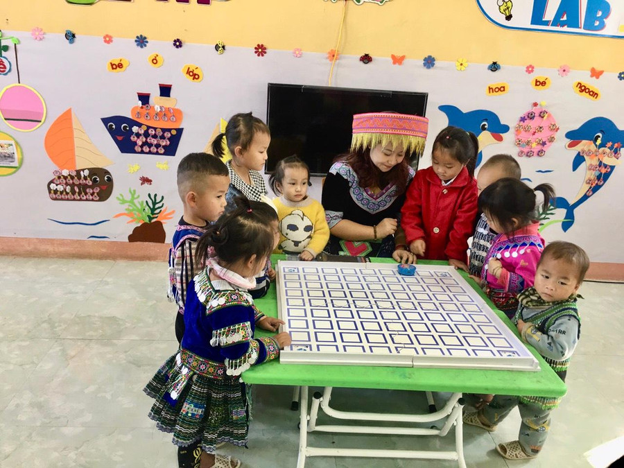 Cô Quyên hướng dẫn học sinh sử dụng robot Vex 123. Ảnh: NVCC.