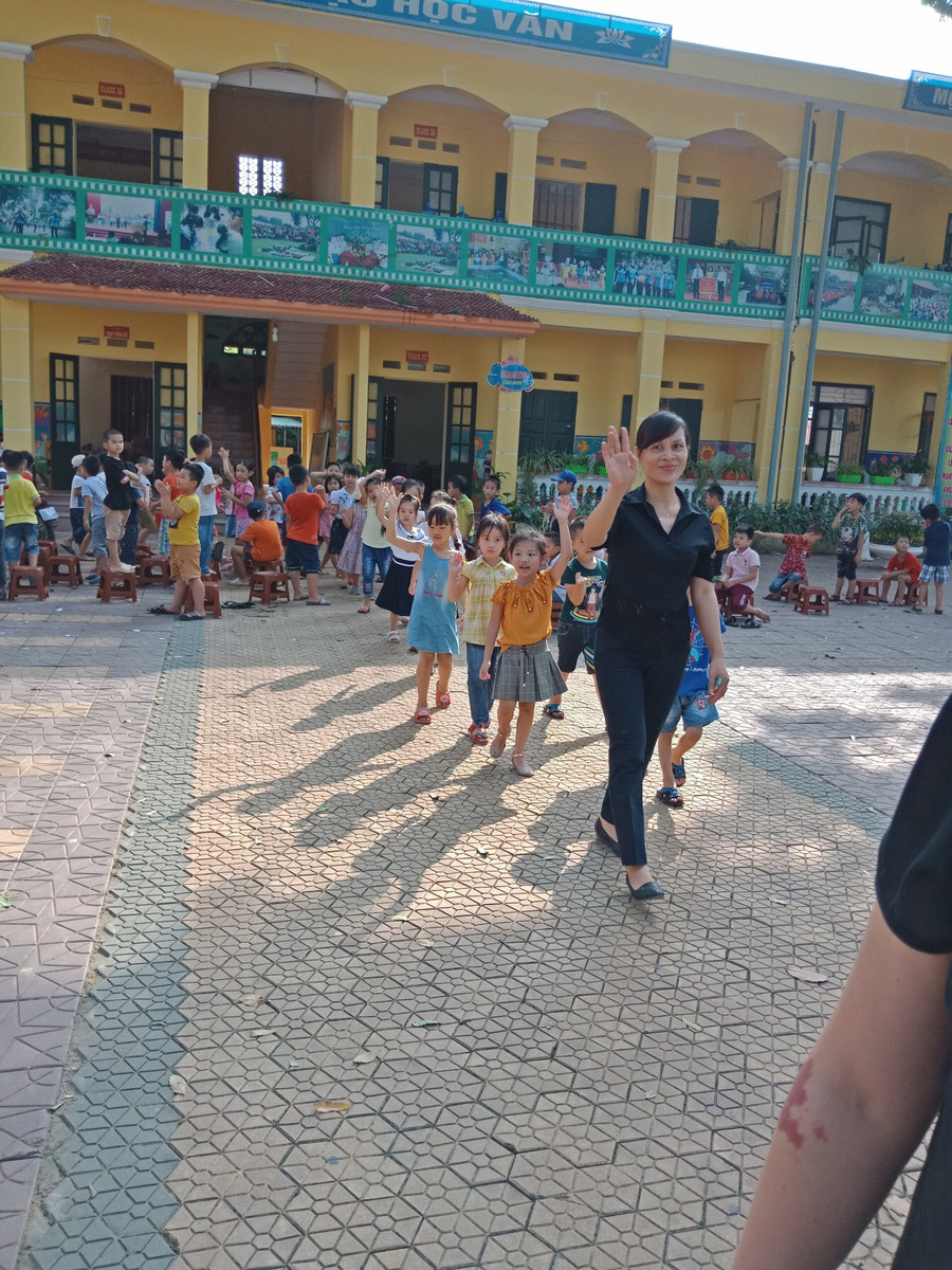 Học sinh lớp 1 được giáo viên chủ nhiệm hướng dẫn cách đi vào vị trí của lớp mình