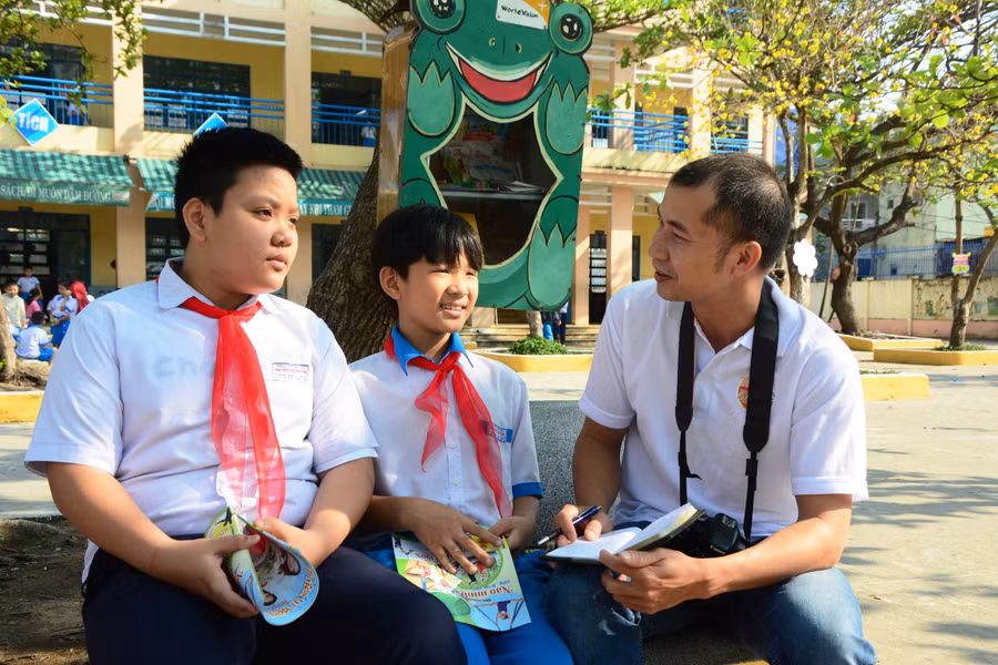 Tác giả Trần Thành (phải) trò chuyện cùng học sinh. Ảnh: NVCC.