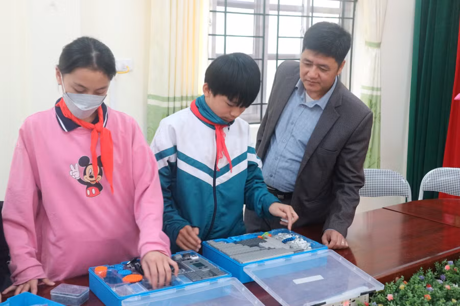 Ông Ngô Văn Hiền (phải) trao đổi với học sinh trên địa bàn huyện.