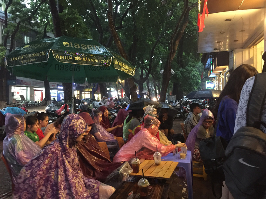 Vỉa hè các quán cà phê, cổ động viên đội mưa để cổ vũ đội nhà