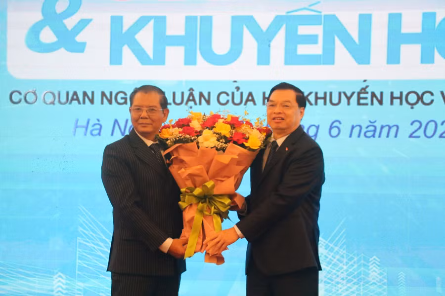 Phó Chủ tịch kiêm Tổng Thư ký Hội Khuyến học Việt Nam Lê Mạnh Hùng (phải) tặng hoa chúc mừng Tổng biên tập Tạp chí Công dân &amp; Khuyến học Tô Quang Phán (trái).