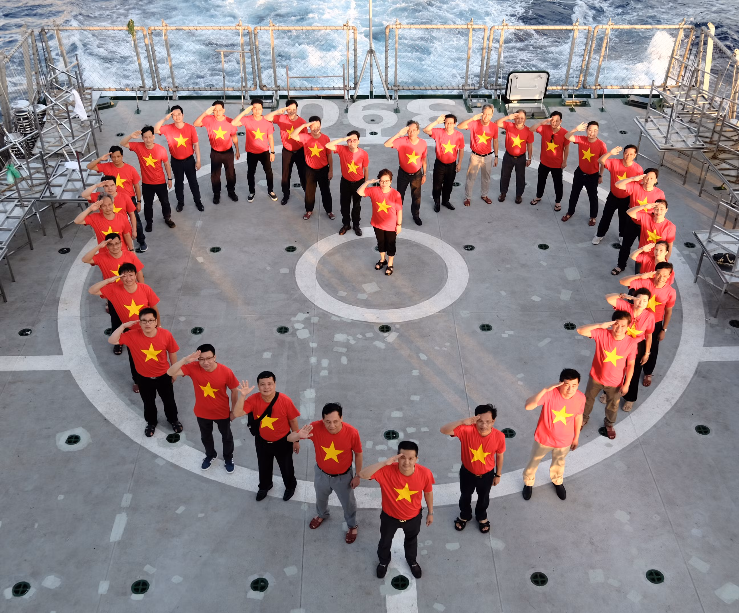 Đoàn công tác cùng nhau xếp hình trái tim trên khu vực sân bay của tàu Kiểm ngư KN390.