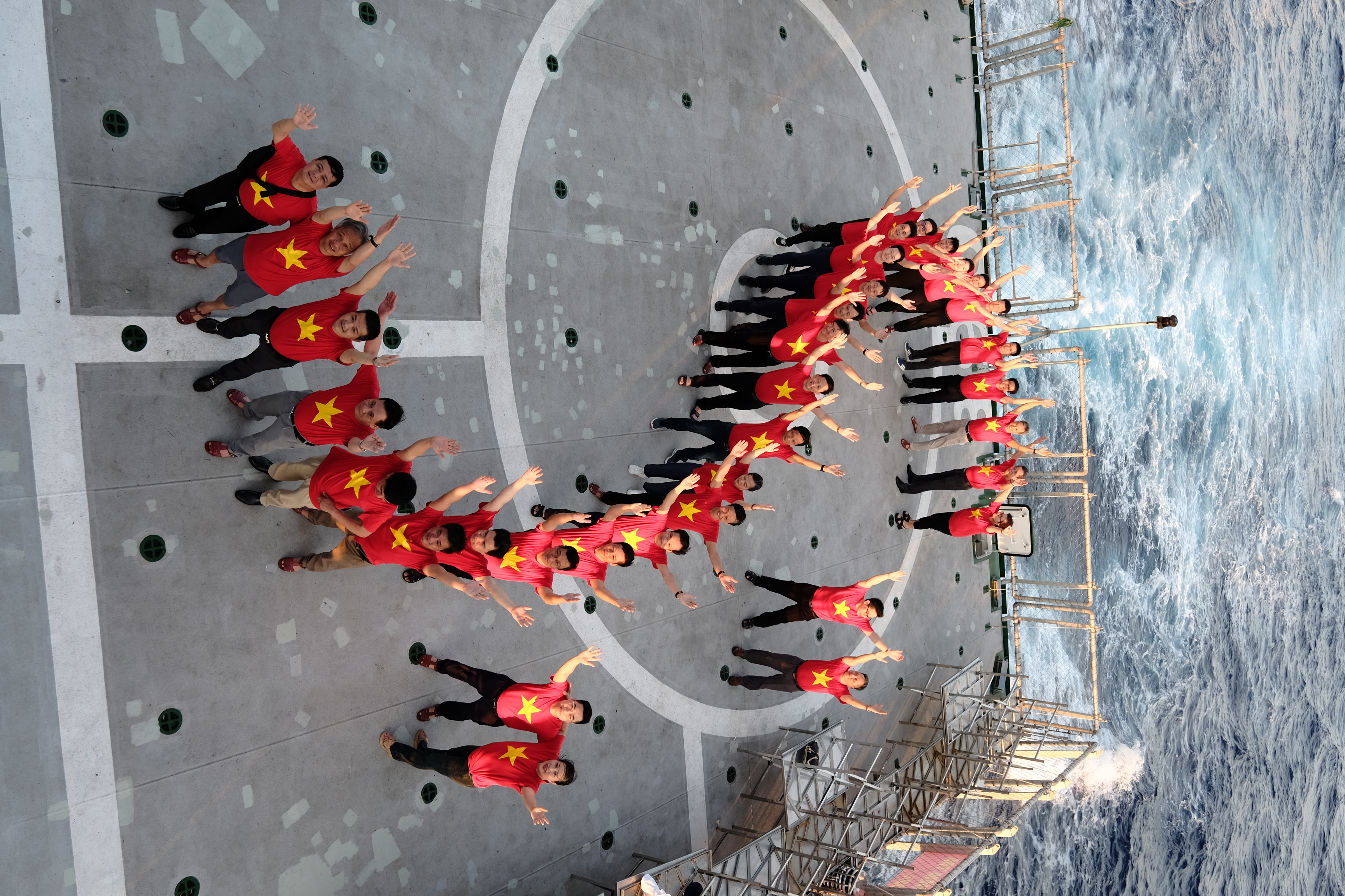 Đoàn công tác cùng nhau xếp hình chữ S trên khu vực sân bay của tàu Kiểm ngư KN390.