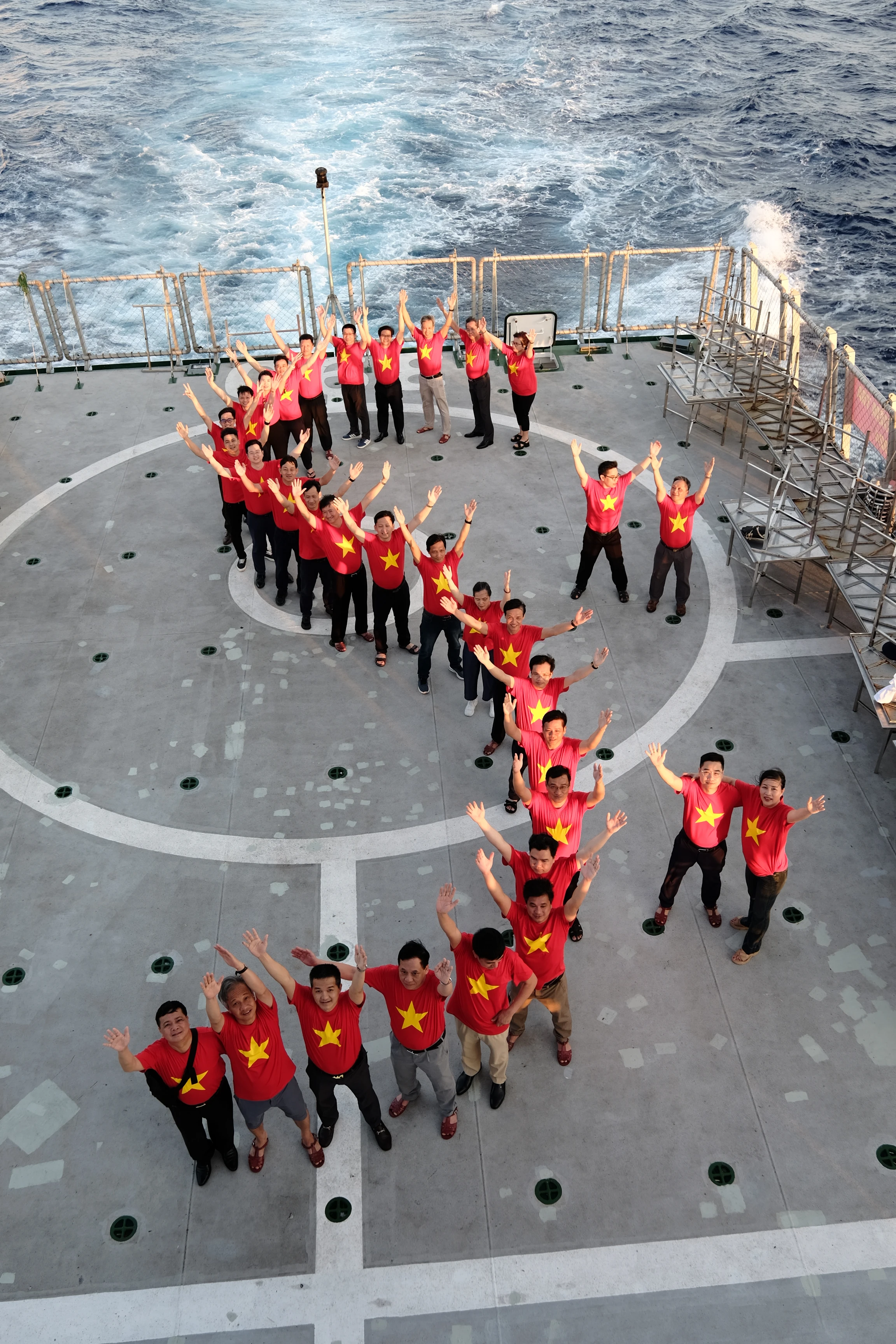 Đoàn công tác cùng nhau xếp hình chữ S trên khu vực sân bay của tàu Kiểm ngư KN390.