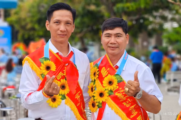 Thầy Trịnh Hoàng Thám (bên trái) chụp ảnh cùng đồng nghiệp khi nhận giải thưởng Cánh én hồng 2025.