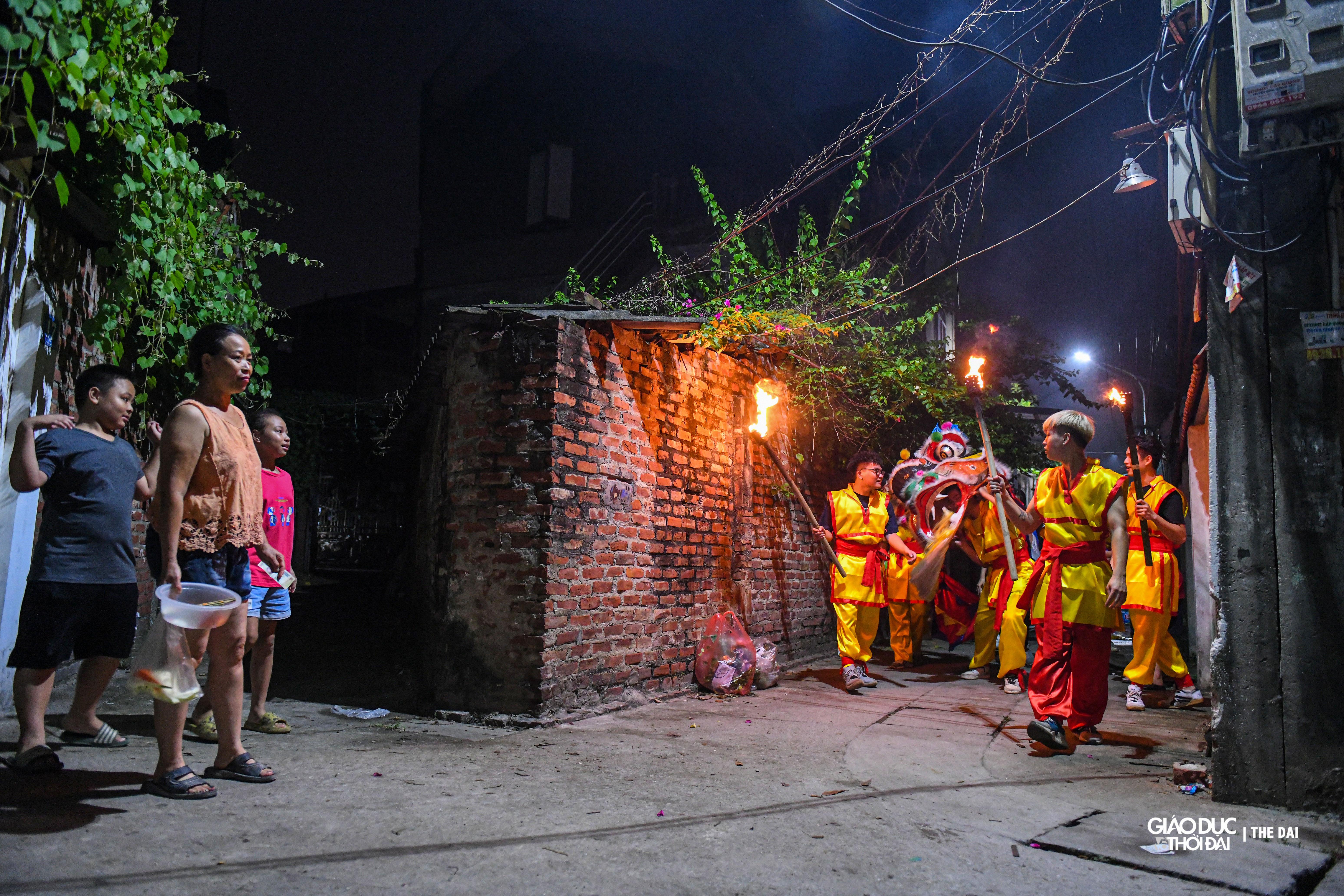 Đội múa lân đi qua từng nhà trong thôn, người già trẻ nhỏ ai cũng háo hức chờ đón.