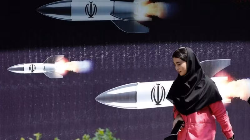 Một phụ nữ Iran đi ngang qua pano chống Israel tại Tehran.