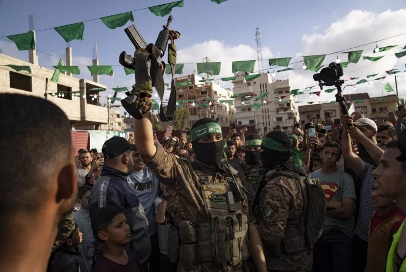 Chiến binh Hamas giơ cao khẩu súng trường biểu tượng của quân đội Israel.